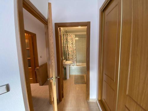 a hallway to a bathroom with a toilet and a sink at S&H La Malcriada in San Juan de los Terreros