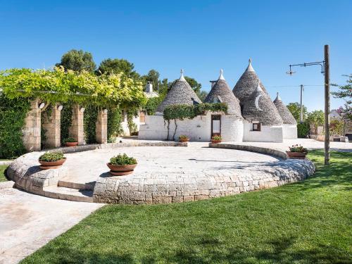 a house with a garden with some plants in it at Trulli Uliveto Acquafonda in Alberobello