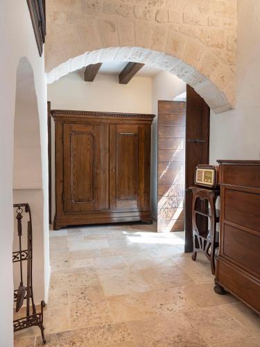 a room with a wooden cabinet and a table at Trulli Uliveto Acquafonda in Alberobello