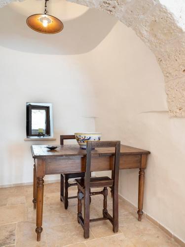 a wooden table with a chair and a mirror at Trulli Uliveto Acquafonda in Alberobello