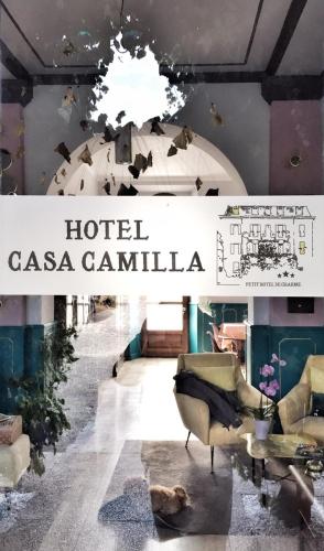 a sign for a hotel casa cantina with chairs and a table at Hotel Casa Camilla in Verbania
