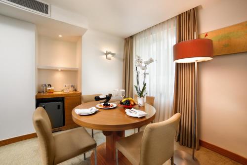 a room with a table and chairs and a kitchen at Divan Istanbul City in Istanbul