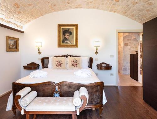 sypialnia z dużym łóżkiem z 2 krzesłami w obiekcie Trulli Uliveto Acquafonda w Alberobello