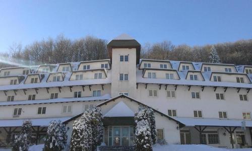 a large white building with a clock tower in the snow at Uni Kop in Brzeće