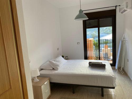 a bedroom with a bed and a large window at S&H La Malcriada in San Juan de los Terreros