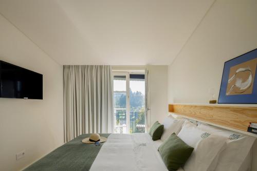 a bedroom with a bed and a large window at Casa do Fontanário Stay in Amarante