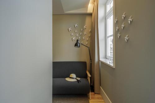 a room with a chair and a lamp and a window at Casa do Fontanário Stay in Amarante