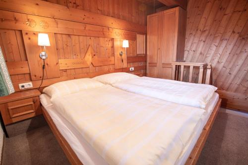 a bedroom with a large bed in a wooden wall at Ferienwohnung Königsleiten 3 Top 5 in Wald im Pinzgau