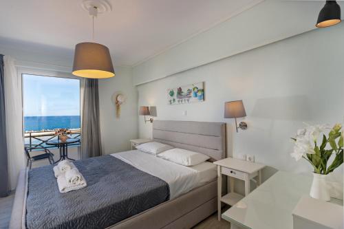 una camera da letto con un letto con vista sull'oceano di Castello Apartments a Panormos