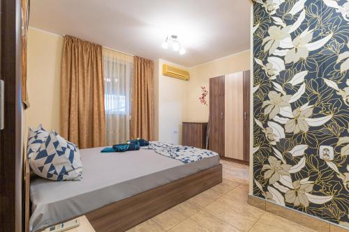 1 dormitorio con 1 cama y una pared con flores en 1BD apartment in a calm area near the centre en Plovdiv