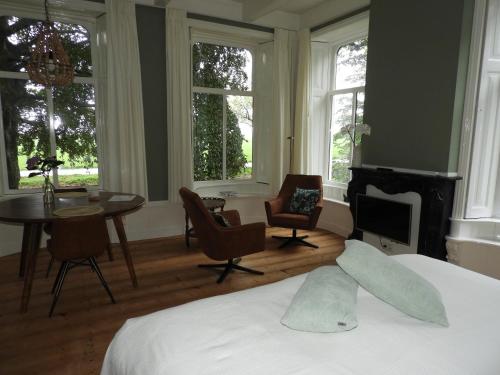 - une chambre avec un lit, une table et des chaises dans l'établissement Het Ellerhoes, à Bedum