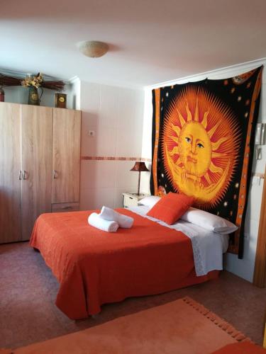 ein Schlafzimmer mit einem Bett mit einem großen Sonnenbild in der Unterkunft TRÍPLEX CON TXOKO EN EZCARAY in Ezcaray