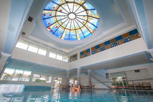 a pool with a stained glass window in a building at Palace Hotel Meggiorato in Abano Terme