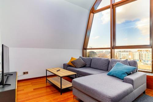 a living room with a couch and a large window at Boogie ApartHouse Old Town in Wrocław