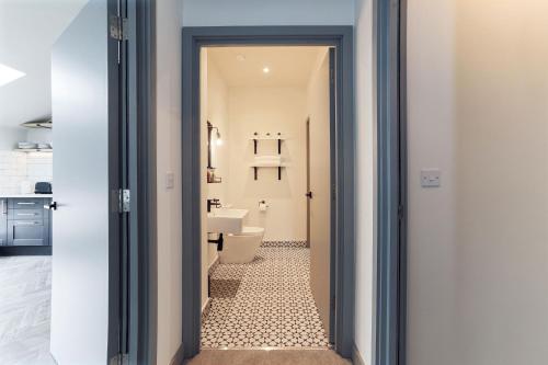 a door leading to a bathroom with a toilet at Goodstay Apartments by Urban Space in Barry