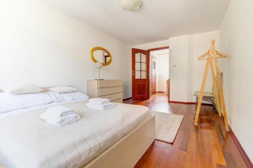 a white bedroom with a bed and a mirror at Krynica Apartamenty 100m Duży Apartament, Salon + 3 sypialnie przy Deptaku in Krynica Zdrój