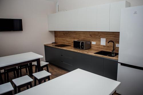 a kitchen with white cabinets and a table and chairs at Новый хостел Nesvit Киев Академгородок in Kyiv