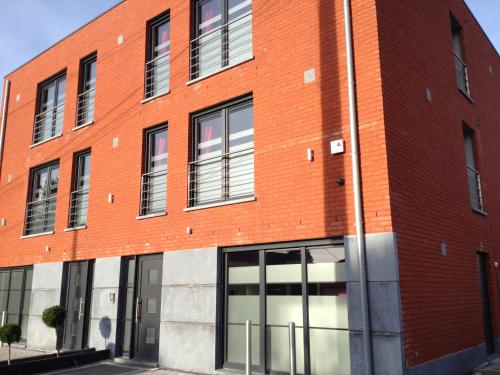 a red brick building with large windows at V E R O N E - Rooms & Suites - Liège - Rocourt in Liège