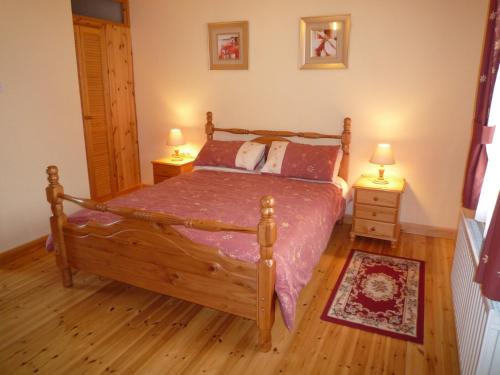 um quarto com uma cama de madeira e 2 mesas de cabeceira em Lakeside Lodge Bantry em Bantry