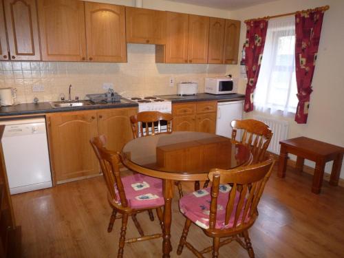 uma cozinha com uma mesa e cadeiras e um lavatório em Lakeside Lodge Bantry em Bantry