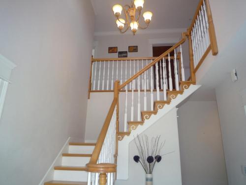 a staircase in a house with a chandelier at Sea View Holiday Home Sheeps HeadBantry in Bantry