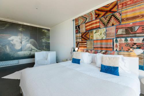 a bedroom with a large white bed and a large mural at Royal Obidos Scenic Resort in Casal da Lagoa Seca