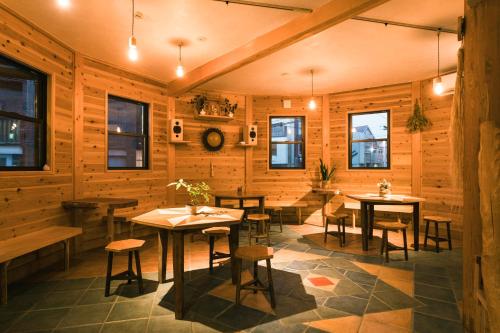 a restaurant with wooden walls and tables and chairs at Ise Guest House Kazami in Ise