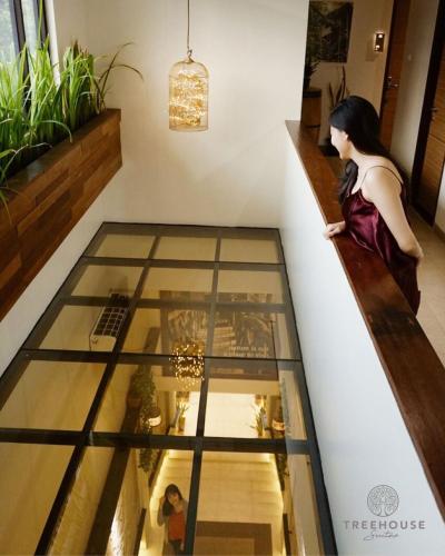 a woman looking into a glass display case in a store at Treehouse Suites - Boutique Serviced Apartment in Jakarta