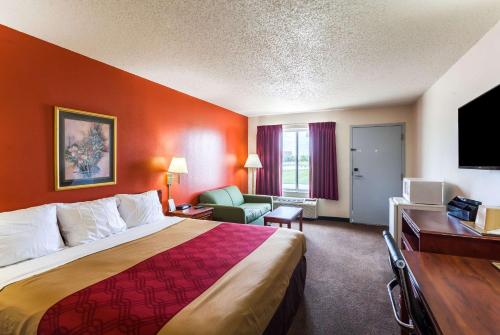 um quarto de hotel com uma cama grande e uma secretária em Econo Lodge Lincoln em Lincoln