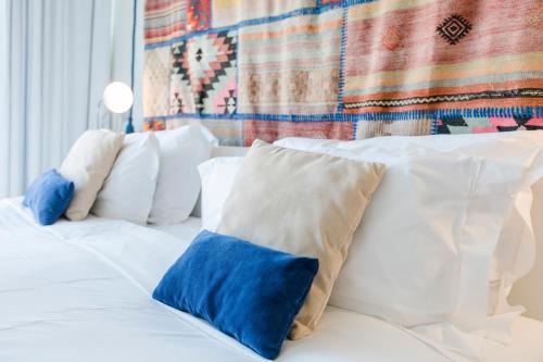 a white bed with blue and white pillows on it at Royal Obidos Scenic Resort in Casal da Lagoa Seca
