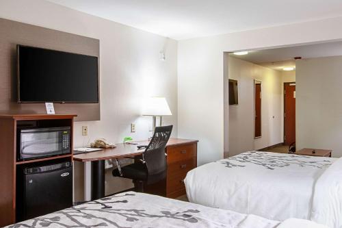 a hotel room with a desk with a computer and a tv at Sleep Inn & Suites in Hobbs