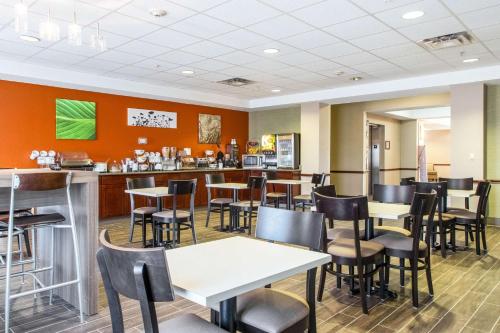 a restaurant with tables and chairs and a bar at Sleep Inn & Suites in Hobbs