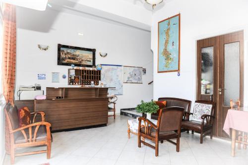 een kamer met stoelen, een tafel en een tv bij Hotel Karpathos in Karpathos