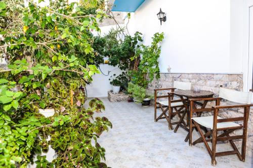 un patio con mesa, sillas y plantas en Hotel Karpathos, en Karpathos