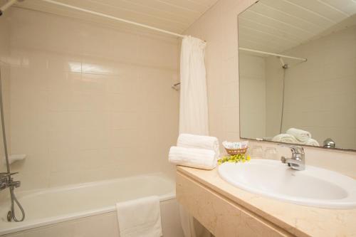 a bathroom with a sink and a tub and a mirror at Mix Colombo in S'Illot