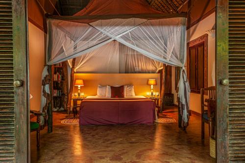 una camera con letto a baldacchino di Fumba Beach Lodge a Fumba