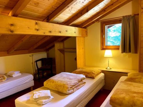 a bedroom with two beds in a room with a window at La Joly - ChaletYap in La Chapelle-dʼAbondance