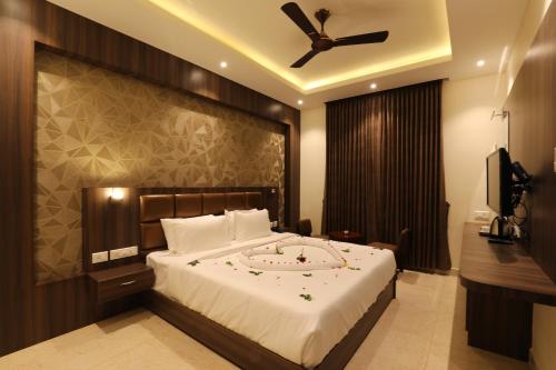 a bedroom with a large bed with a ceiling fan at Mayuraa Residency in Chennai