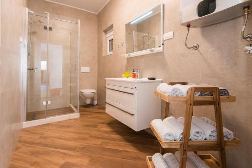 uma casa de banho com um chuveiro, um lavatório e um WC. em Villa Belle Air em Herceg Novi