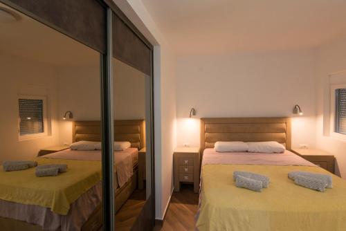 1 dormitorio con 2 camas y espejo en Villa Belle Air, en Herceg-Novi