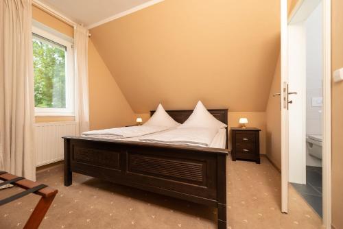 Un dormitorio con una cama con almohadas blancas. en Hotel Wasserschlößchen en Naumburg (Saale)