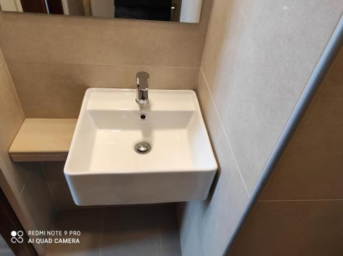 a bathroom with a white sink and a mirror at Porto Lesvos hotel in Mytilini