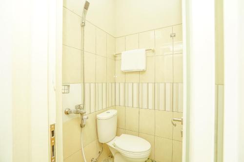 a bathroom with a toilet and a shower at Ardhya Guesthouse Syariah by ecommerceloka in Sidoarjo