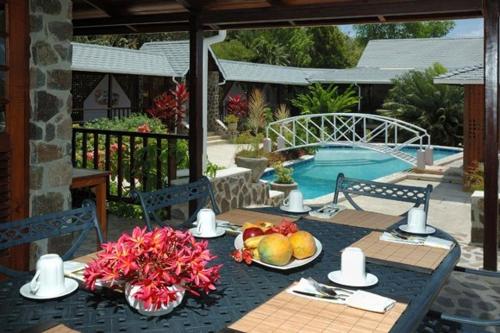 a table with fruit on it next to a pool at Spring Hotel Bequia in Port Elizabeth