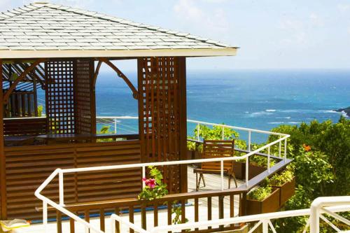a deck with a gazebo and the ocean at Spring Hotel Bequia in Port Elizabeth