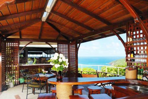 a restaurant with a table and chairs and the ocean at Spring Hotel Bequia in Port Elizabeth
