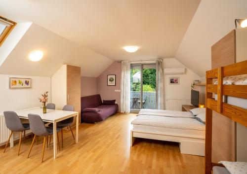 een slaapkamer met een bed, een tafel en een bank bij Apartment Muznik in Bled