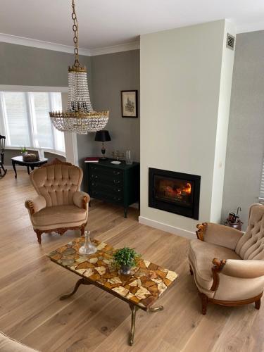 a living room with a chandelier and a fireplace at B&B Gellick in Lanaken