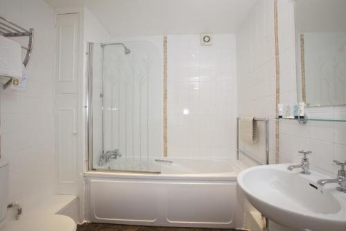 a white bathroom with a tub and a sink at Fisherman's Cot, Tiverton by Marston's Inns in Tiverton