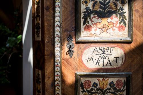 a wooden door with paintings and signs on it at Romantik Hotel & Restaurant Stafler in Vipiteno